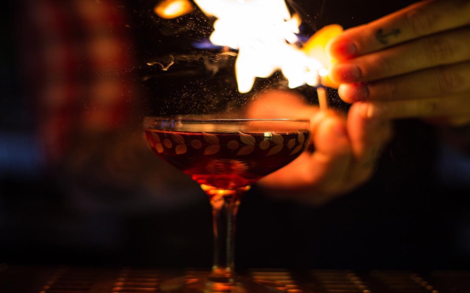 Fire alight above cocktail at the Keefer Bar, Vancouver
