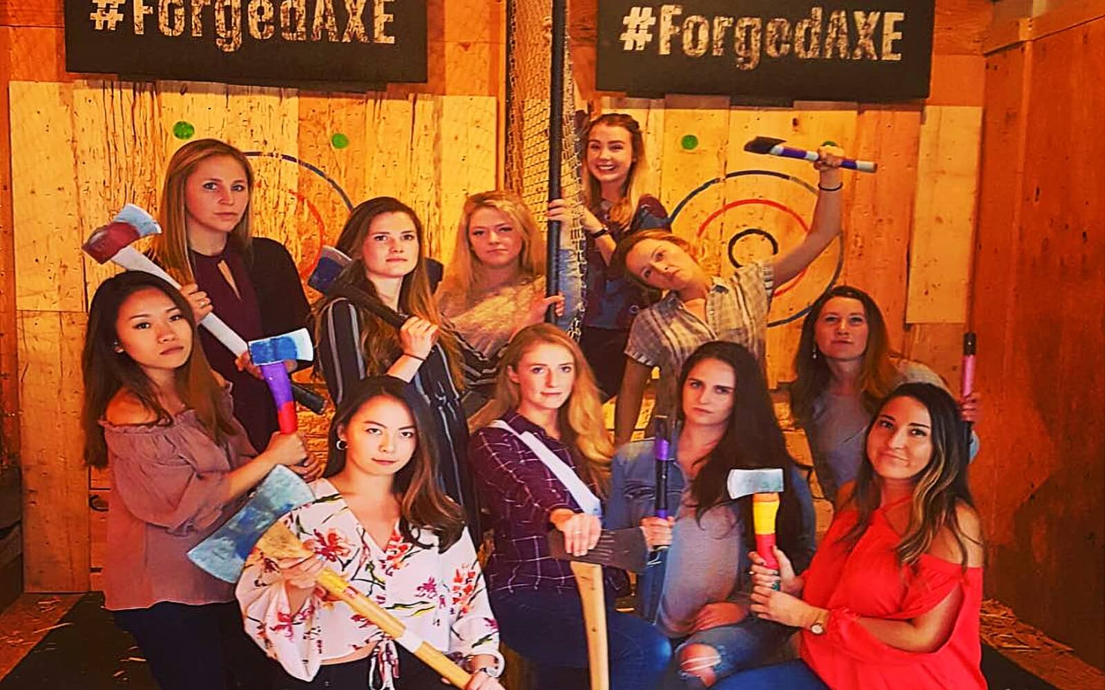 A group of woman pose after a axe throwing contest
