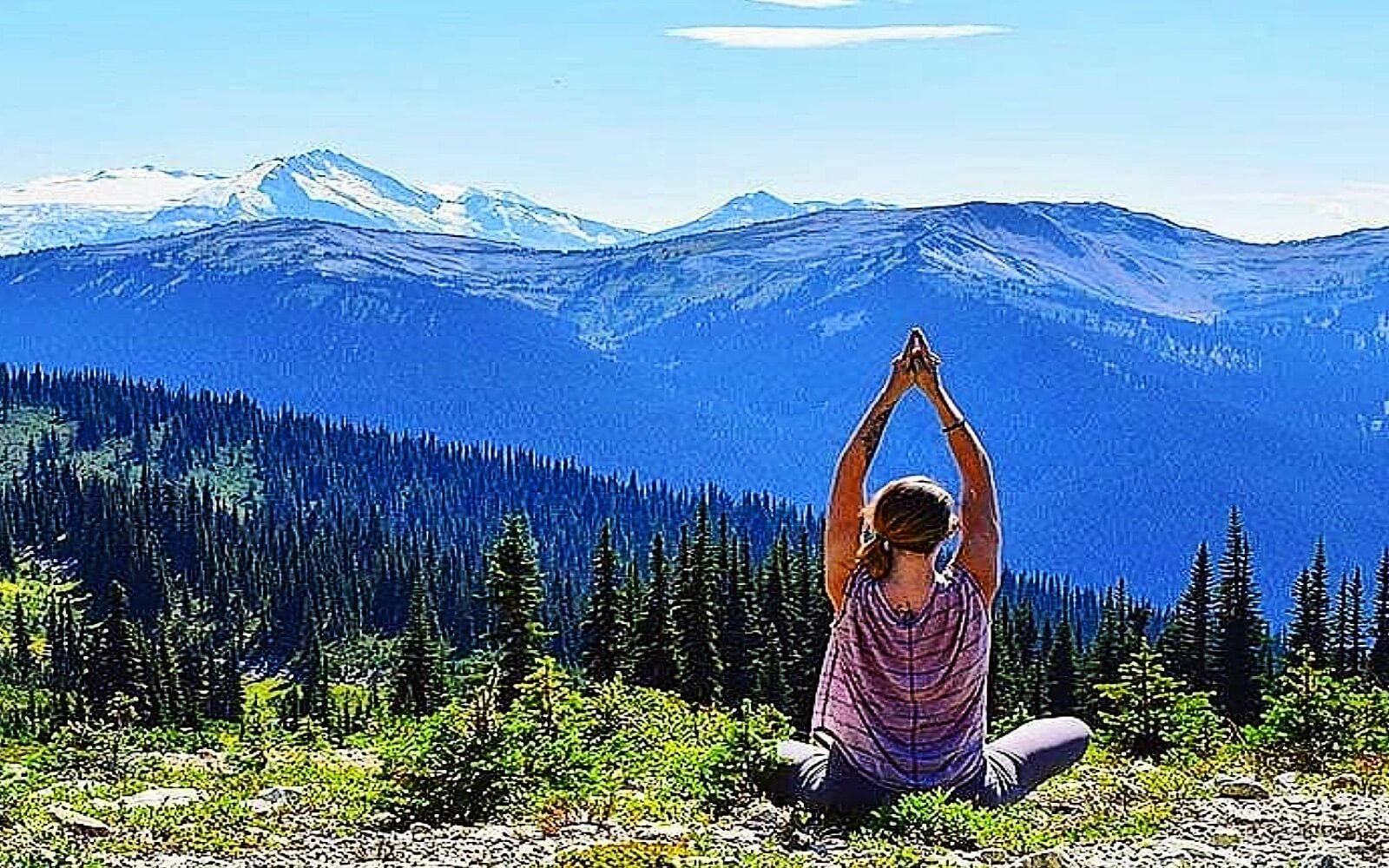 A woman does yoga in the mountains