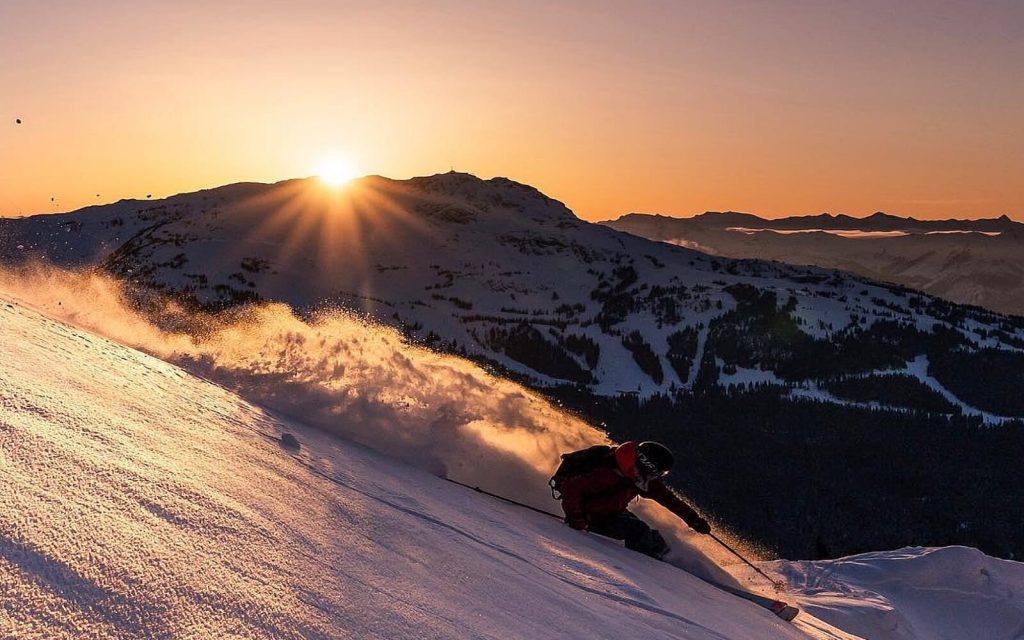 A skier slaloms down Whistler Mountain at dawn