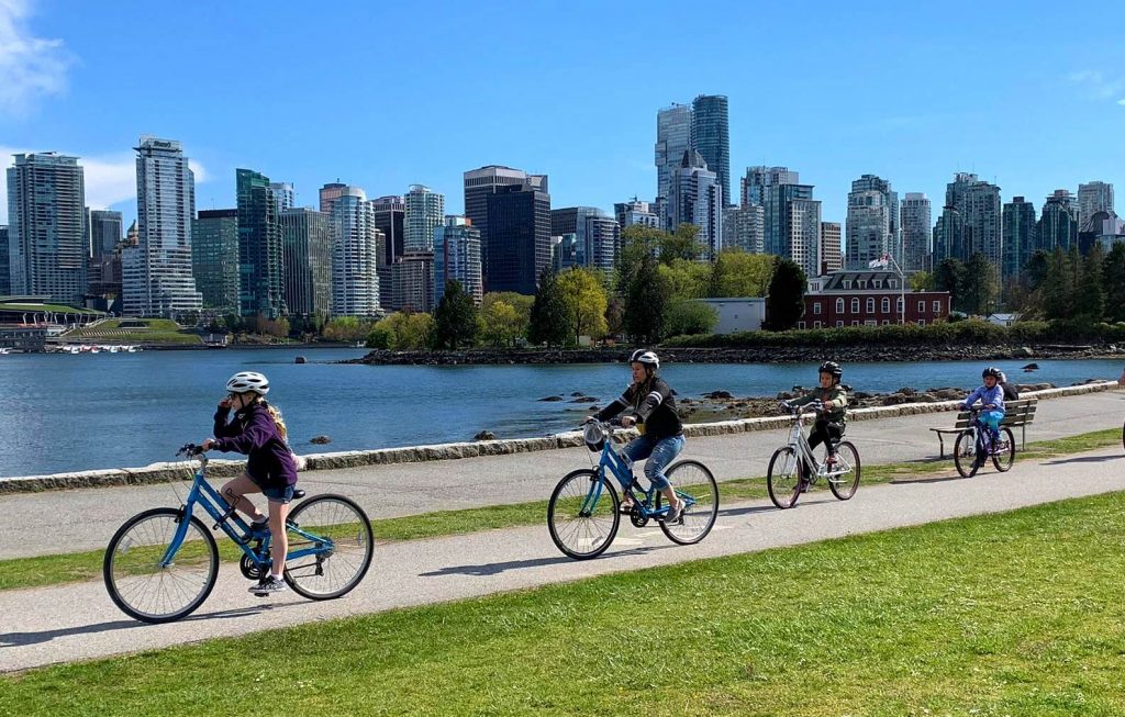 A family bikes around Vancouver’s Seawall