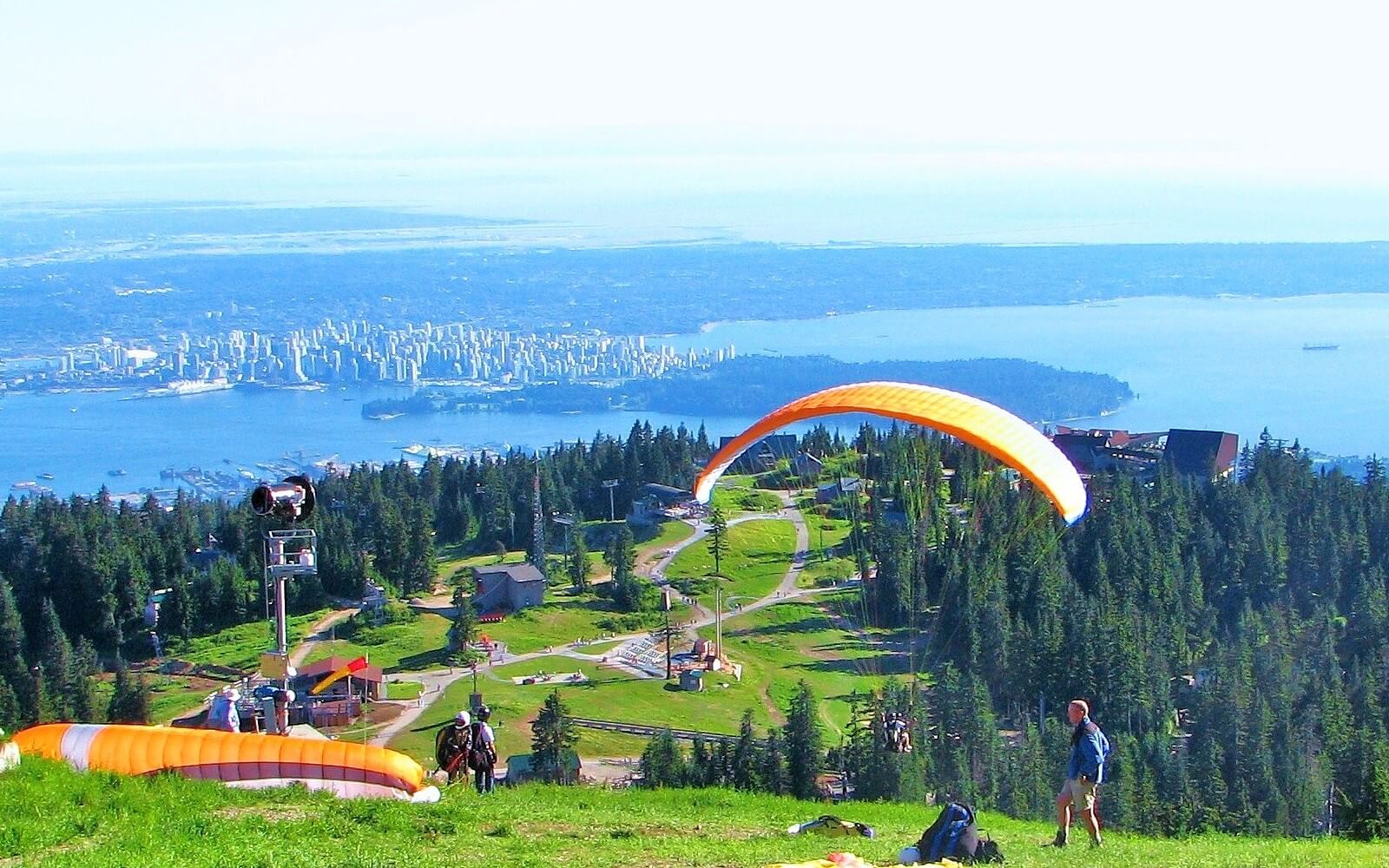 hikers look down on vancovuer canada from grouse mountain