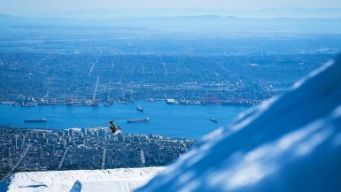 A skier jumps on Grouse Mountain in front of the Vancouver skyline
