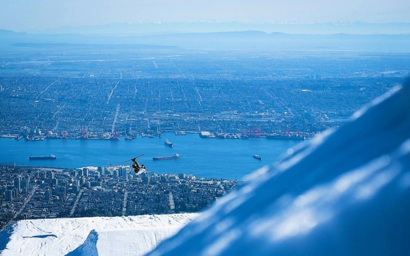 A skier jumps on Grouse Mountain in front of the Vancouver skyline