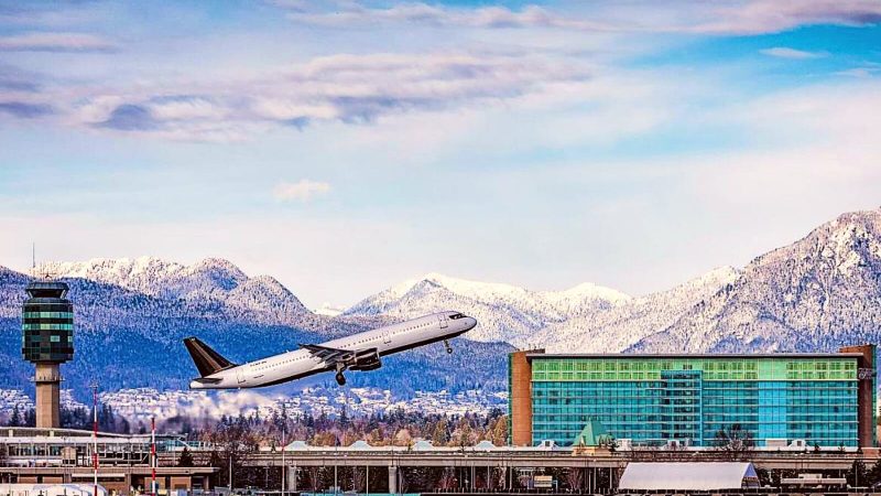 A plane takes off in front of the Fairmont Vancouver Airport