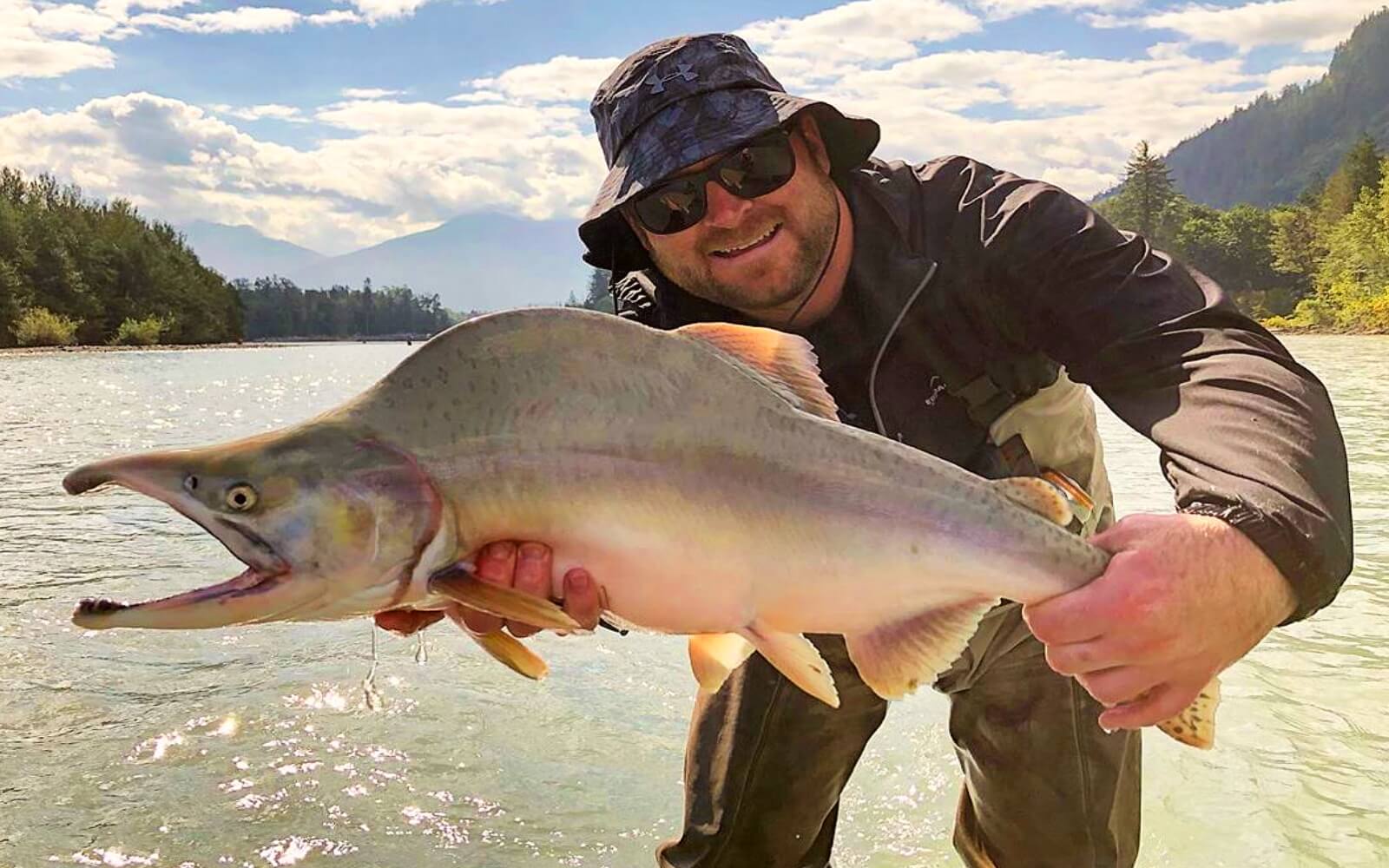 A man holds a large pink salmon