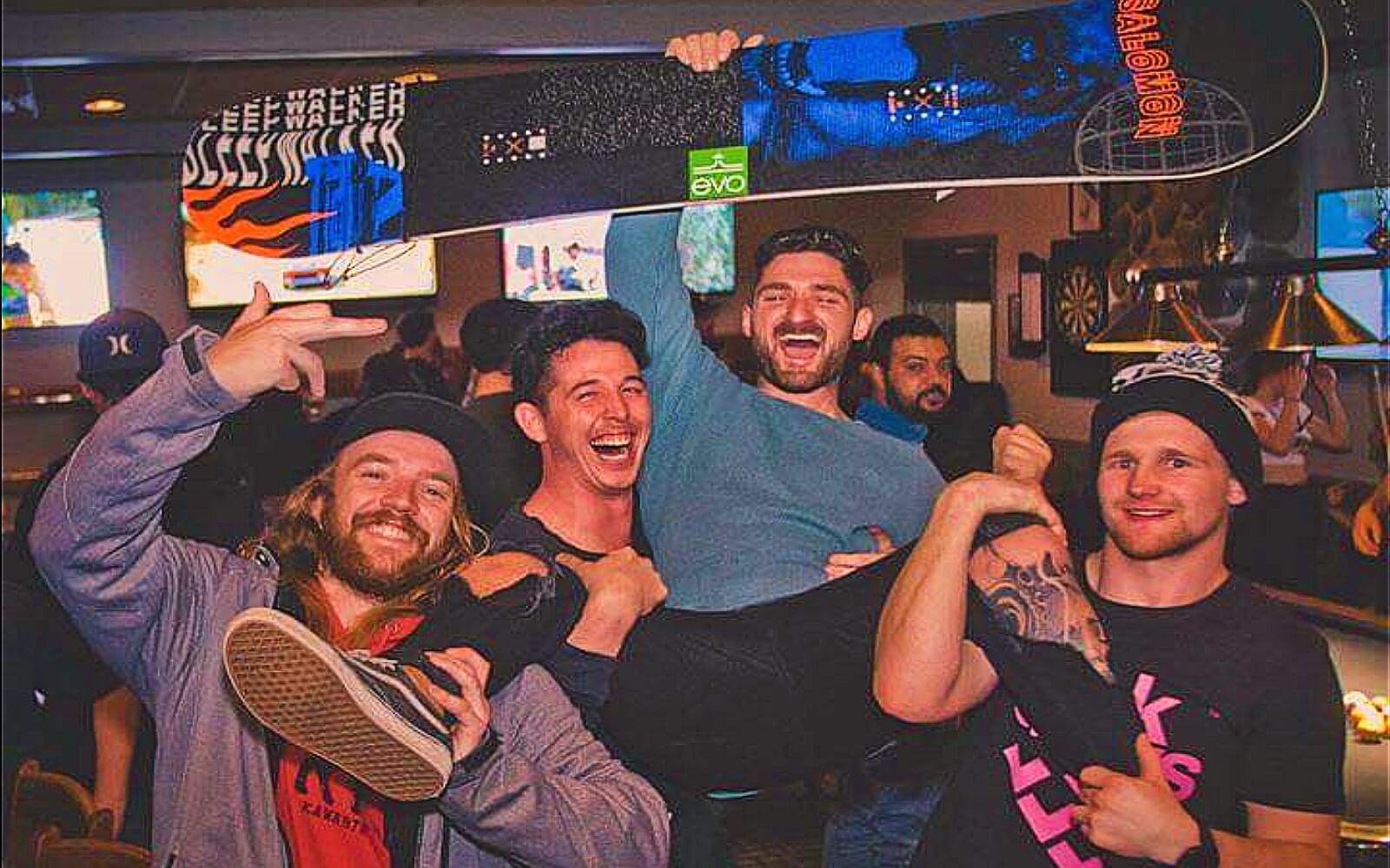 A group of men celebrate winning a snowboard, Crystal Lounge Whistler