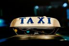 a taxi sign illuminated at night