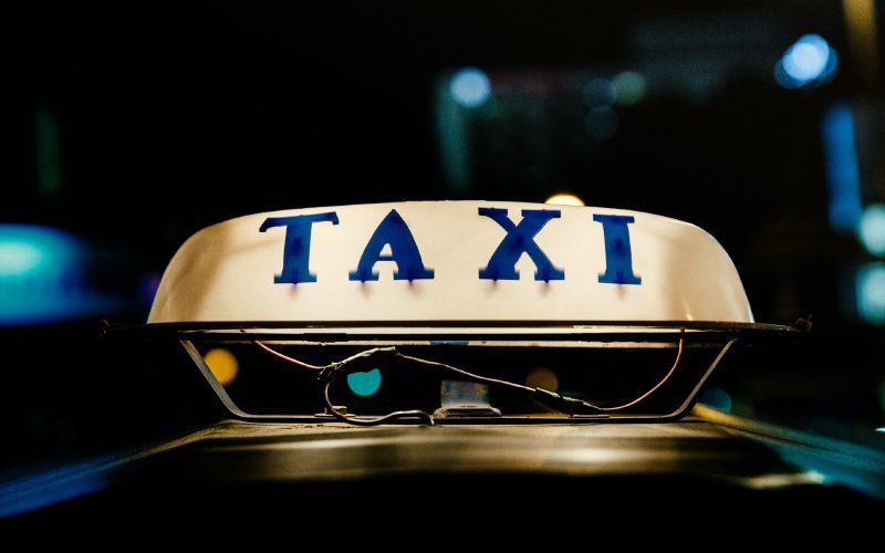 a taxi sign illuminated at night
