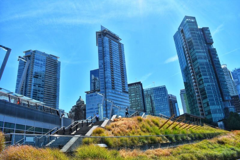 coal harbour blue glass towers contrasting a grassy knoll at the vancouver convention centre