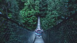 a girl crosses the Lynn Canyon Suspension Bridge, one of my favourite Vancouver hidden gems.