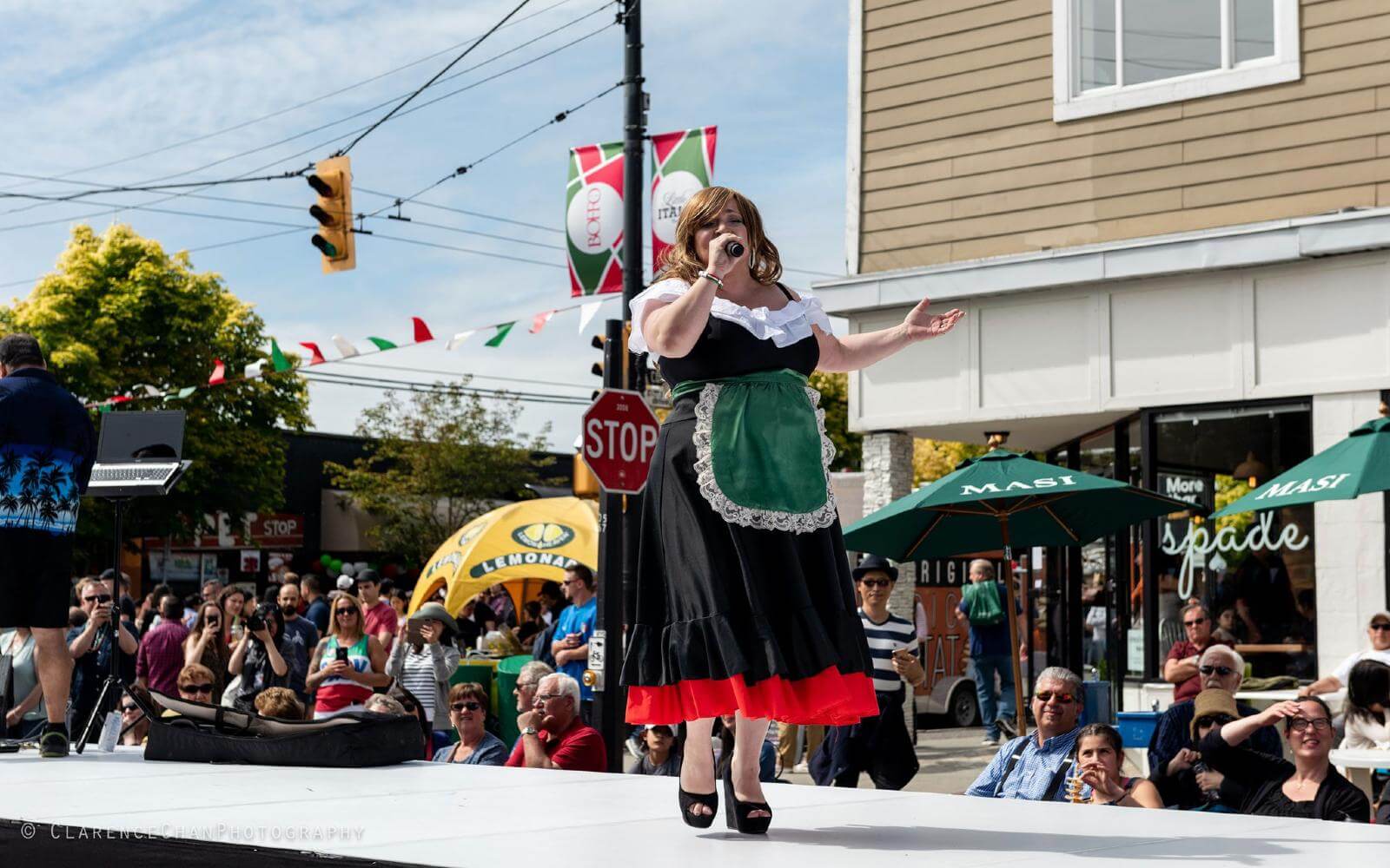 a woman in traditional italian dress singing on commercial drive during italian day in vancouver bc canada