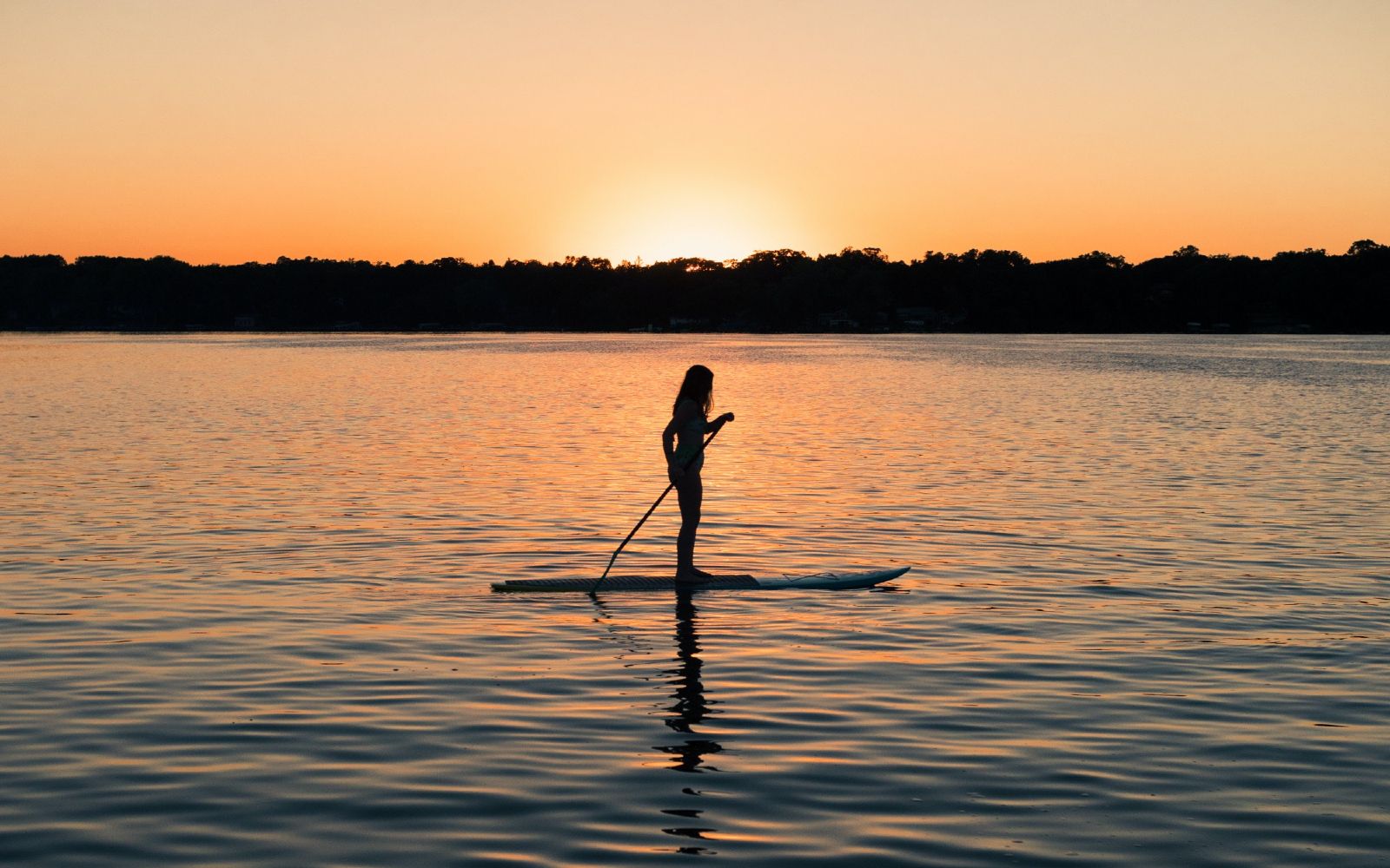 A woman paddleboards at sunset, Victoria BC