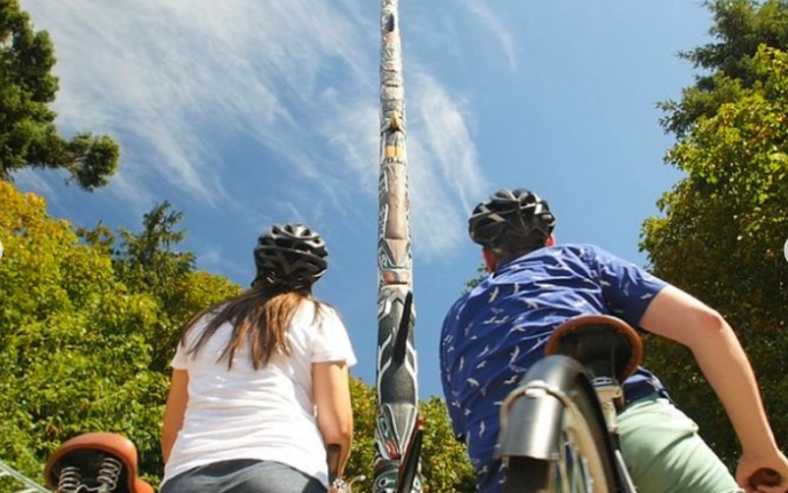 Two bikers marvel at the massive totem in Beacon Hill Park, Victoria BC