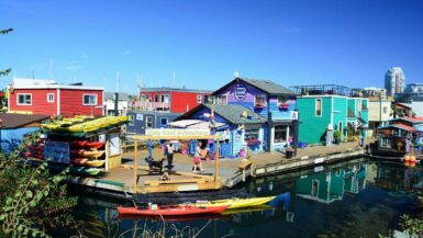 tourists walking by a kayak rental shop at fishermens wharf in victoria bc canada