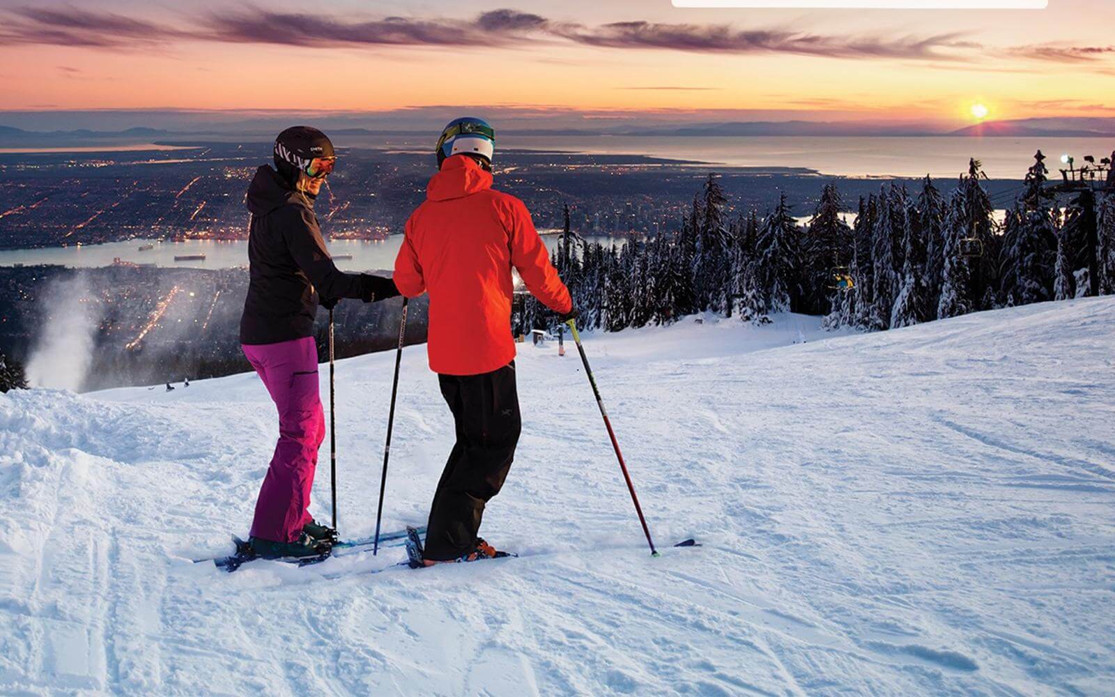 a couple looking at the city of vancouver while night skiing at grouse mountain