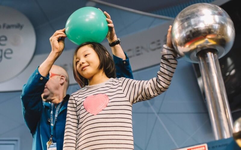 a child participating in an electrical current experiment at science world in vancouver bc canada