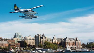 a vancouver to victoria seaplane flying over downtown victoria with the empress hotel