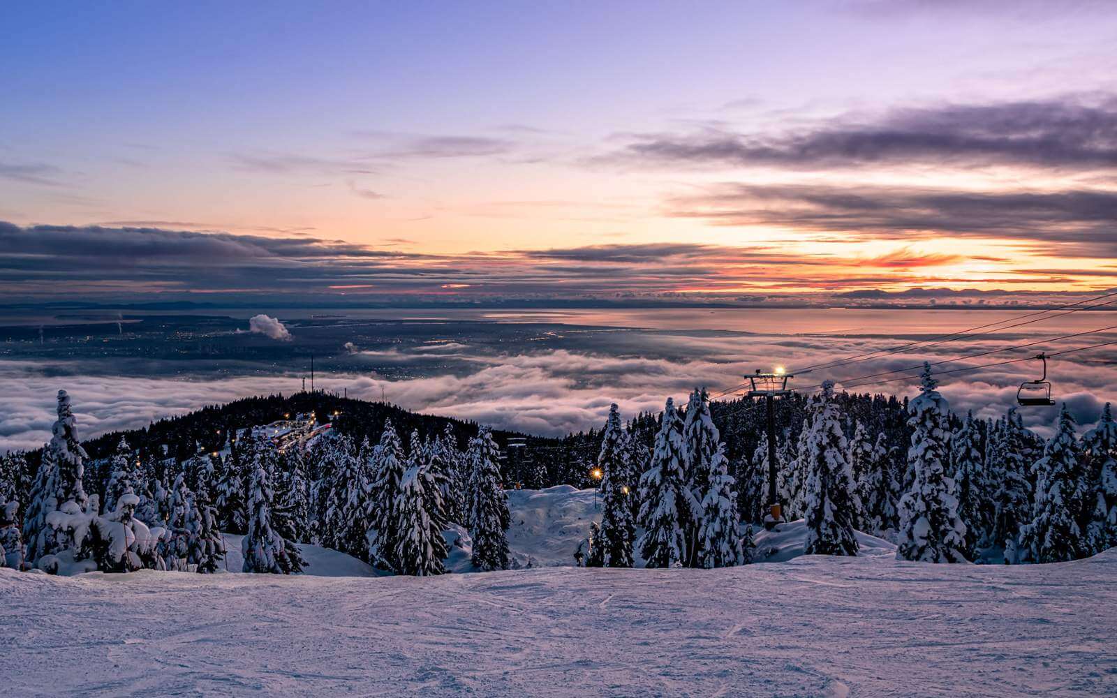 view of mount seymour ski terrain at sunset over the city of vancouver