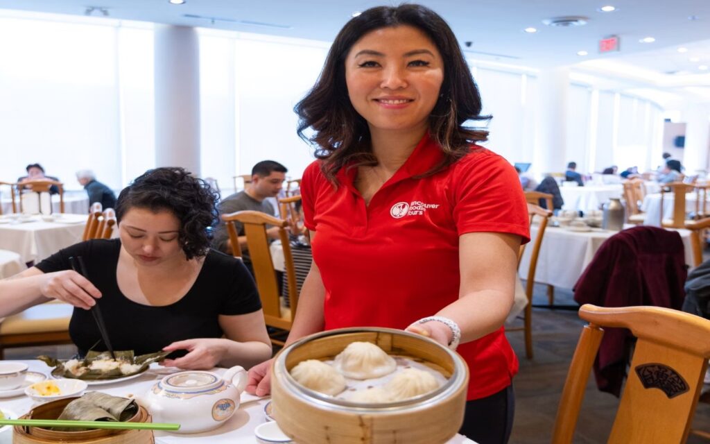 a woman serves dumplings on a vancouver food tour