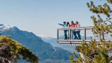 visitors standing at a viewpoint at the sea to sky gondola in squamish bc