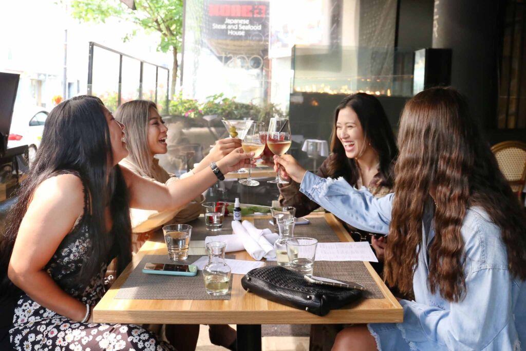 group of women raising their glasses for a toast in coast restaurant in vancouver bc canada