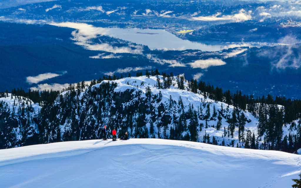 snowshoeing individuals on top of a snowy mount seymour in bc canada