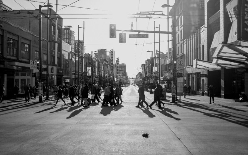 pedestrians cross at the intersection of granville and robson street.