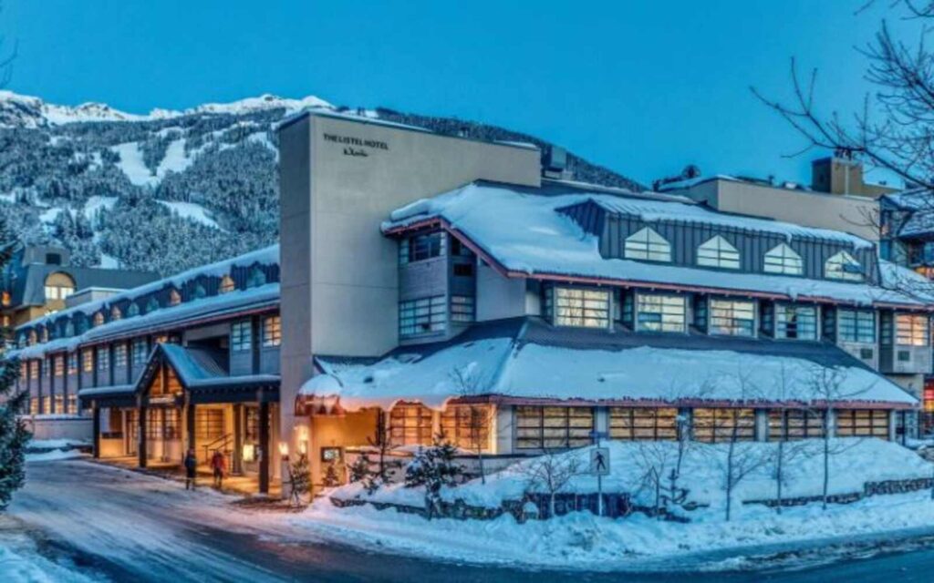outside view of the listel hotel whistler on a snowy weather with the orange lights showing 

