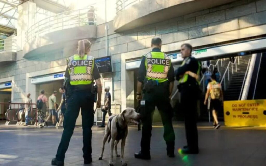 three transit police with their dog standing near the public vancouver transport system