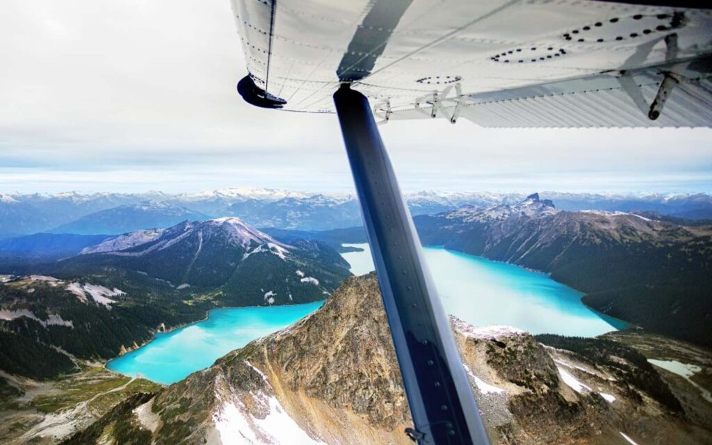 vancouver to whistler seaplane flying over a crystal blue lake in bc