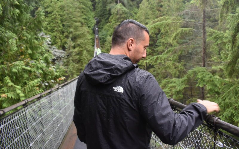a man looking over the side of capilano suspension bridge