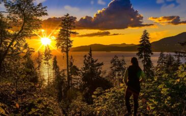 A women admires the sunset during the ultimate walking experience at Stanley Park.
