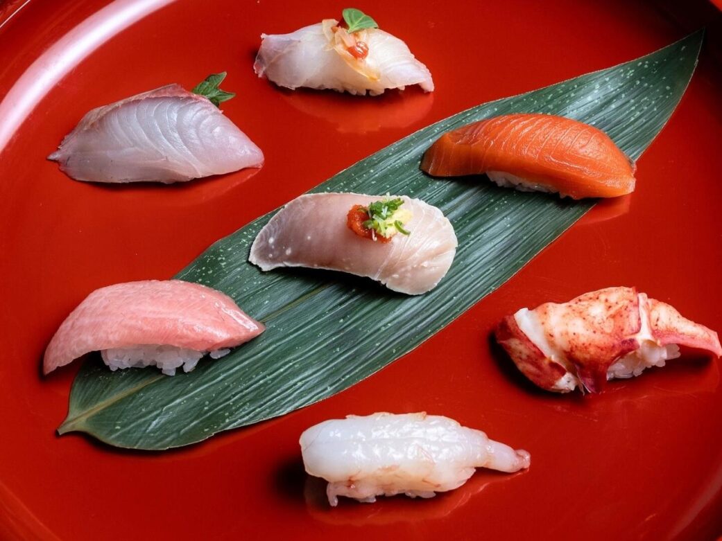 different sushi perfectly placed on a red plate