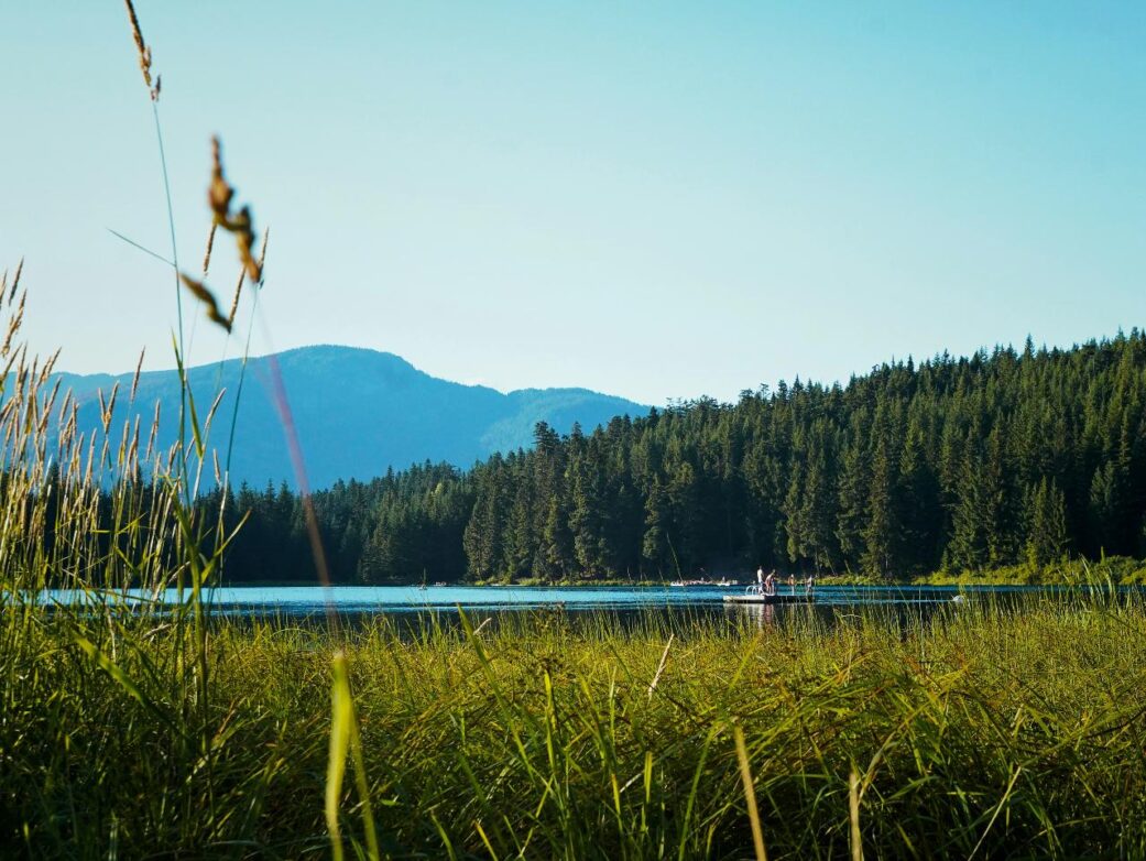 A group stands on the swimming dock on Lost Lake, Whistler, BC.