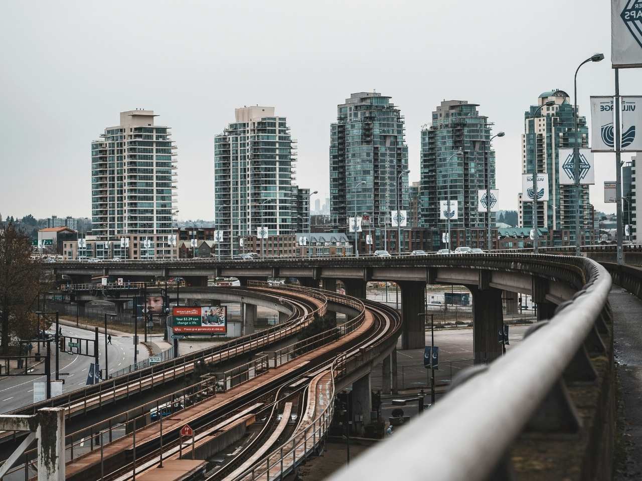 train tracks with city building at the background