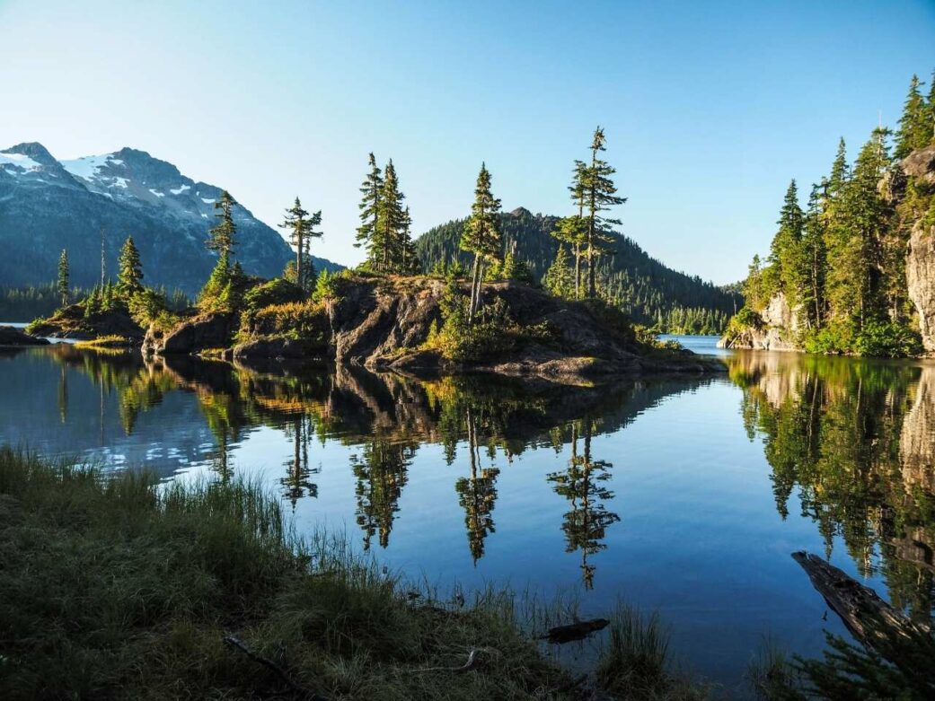 amazing scenery of vancouver island with crystal clear water, large trees hovering over the island perfect on how to get to vancouver island from vancouver