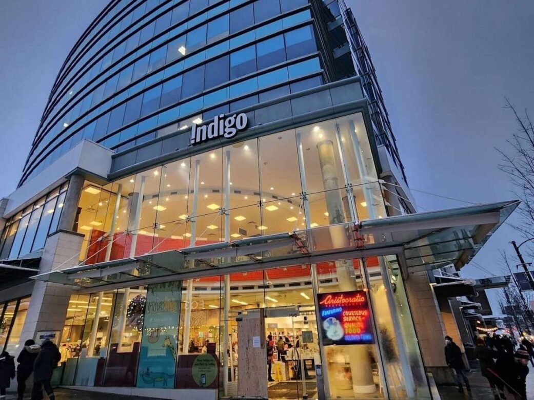 a glass building lit up at night with the name indigo at granville street