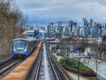 this image shows a vancouver skytrain heading into downtown, with bc place stadium and the city skyline in the background. although the skytrain connects many metro vancouver areas, it does not go directly to tsawwassen ferry terminal. travelers must transfer to a bus or use a ferry connector service.
