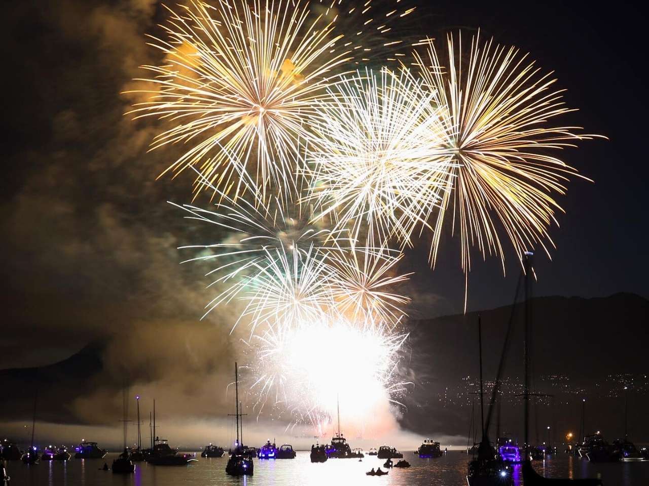 a beautiful display of fireworks during celebration of light in vancouver with people watching from the boats