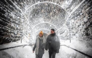A couple walks through the light tunnel at Christmas on Grouse Mountain.