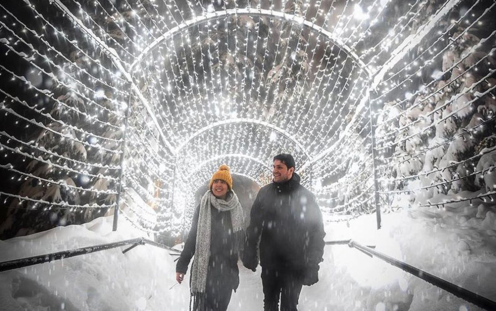 A couple walks through the light tunnel at Christmas on Grouse Mountain.