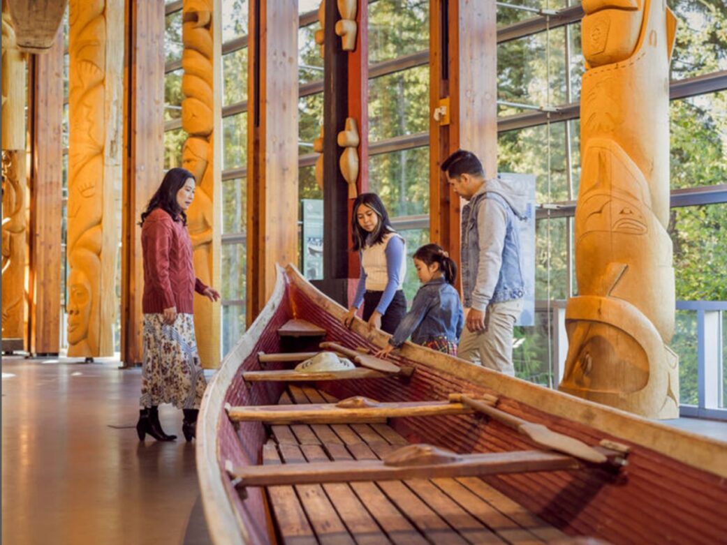 A family admires a canoe at the Squamish Lil'Wat Cultural Centre, Whistler, BC.